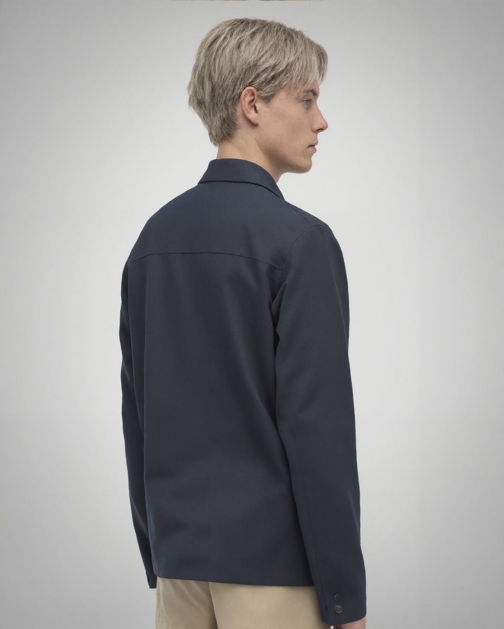 Navy blue cotton twill utility overshirt with a relaxed fit. Features a four-button front closure, two oversized flap pockets, refined topstitching, and a soft matte finish. Fully lined for added structure and durability. Designed for effortless layering and cut and sewn in Australia.