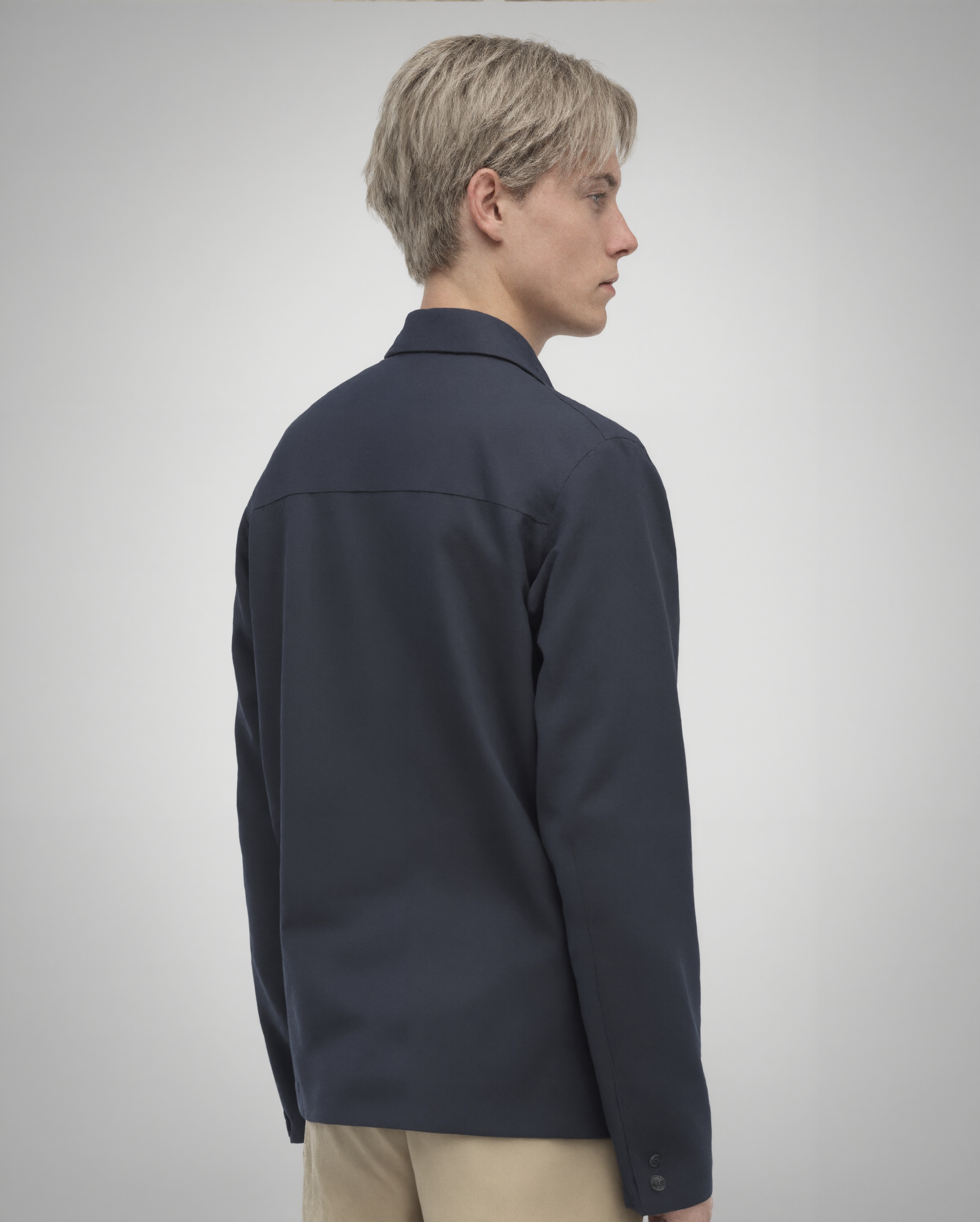 Navy blue cotton twill utility overshirt with a relaxed fit. Features a four-button front closure, two oversized flap pockets, refined topstitching, and a soft matte finish. Fully lined for added structure and durability. Designed for effortless layering and cut and sewn in Australia.