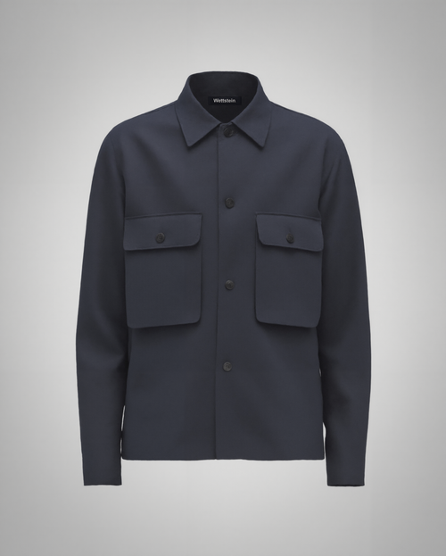 Navy blue cotton twill utility overshirt with a relaxed fit. Features a four-button front closure, two oversized flap pockets, refined topstitching, and a soft matte finish. Fully lined for added structure and durability. Designed for effortless layering and cut and sewn in Australia.