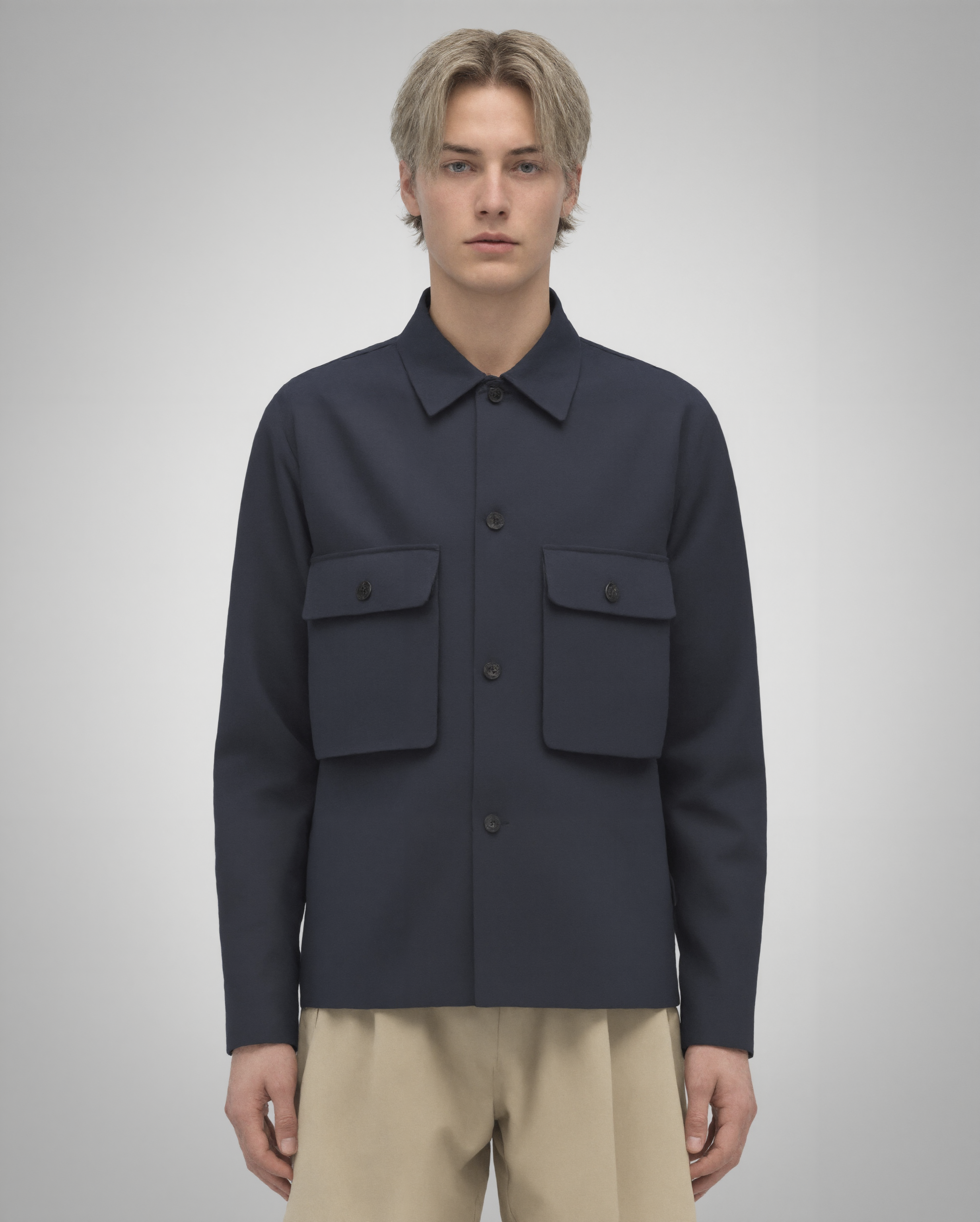 Navy blue cotton twill utility overshirt with a relaxed fit. Features a four-button front closure, two oversized flap pockets, refined topstitching, and a soft matte finish. Fully lined for added structure and durability. Designed for effortless layering and cut and sewn in Australia.